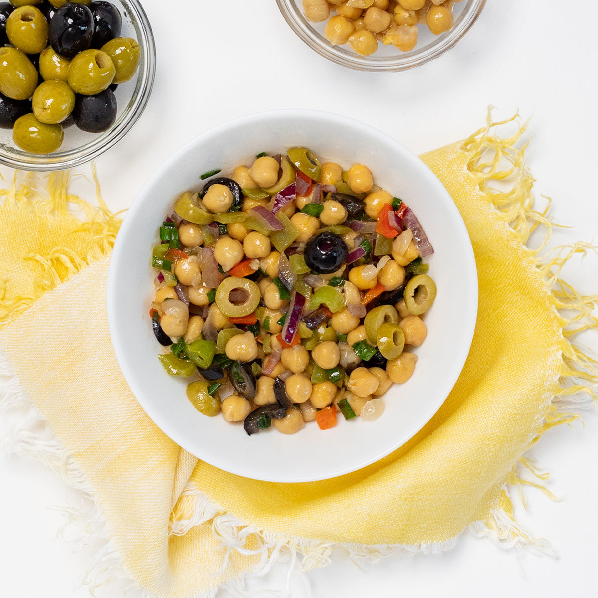 Chickpea Salad with green and black olives, red onion and peppers in a white bowl by Zina's Fine Foods