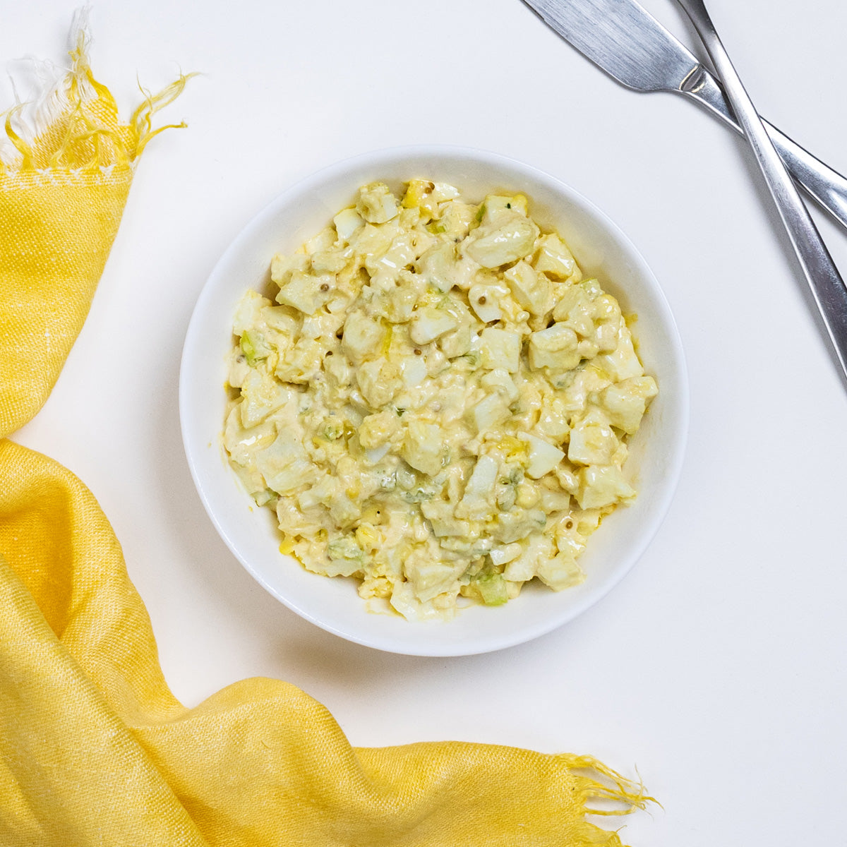 Classic Egg Salad with chopped egg, celery and mustard seeds in a white bowl by Zina's Fine Foods