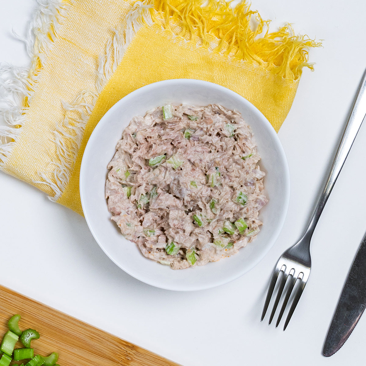 Classic Tuna Salad with flaked tuna and chopped celery in a white bowl by Zina's Fine Foods