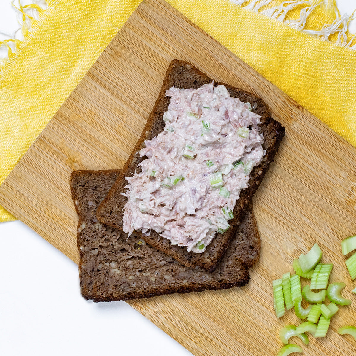 Zina's Fine Foods Classic Tuna Salad spread on dark rye bread with chopped celery