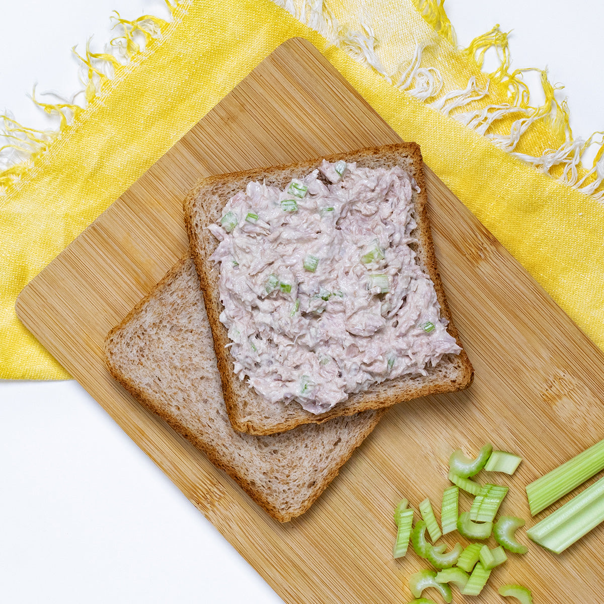 Open-face tuna salad sandwich on wheat bread with celery, made with Zina's Fine Foods Classic Tuna Salad