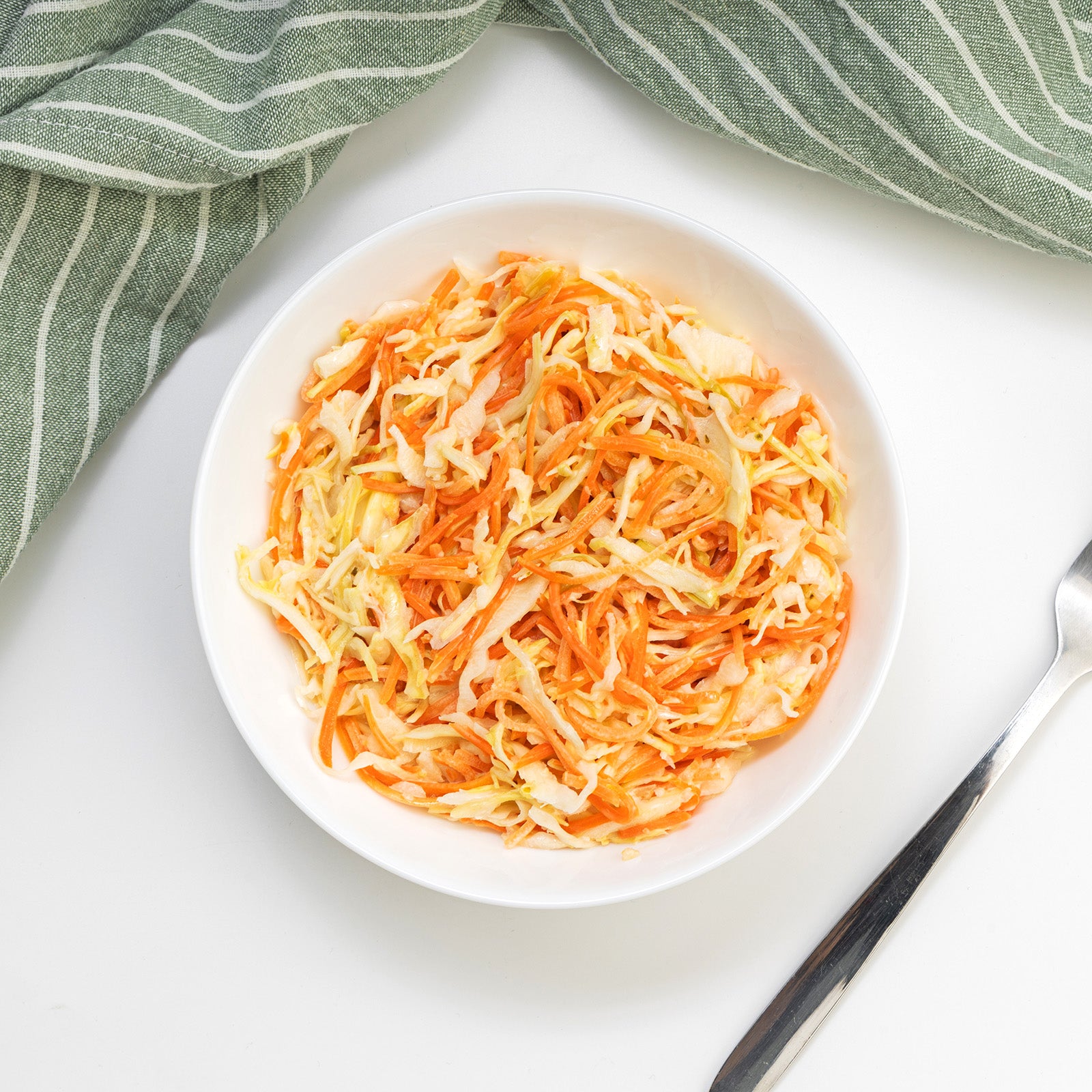 Homestyle Coleslaw Salad with creamy shredded cabbage and carrots in a white bowl by Zina's Fine Foods