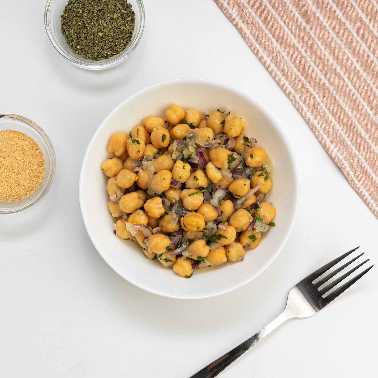 Italian Chickpea Salad with red onion, parsley and herbs in a white bowl by Zina's Fine Foods