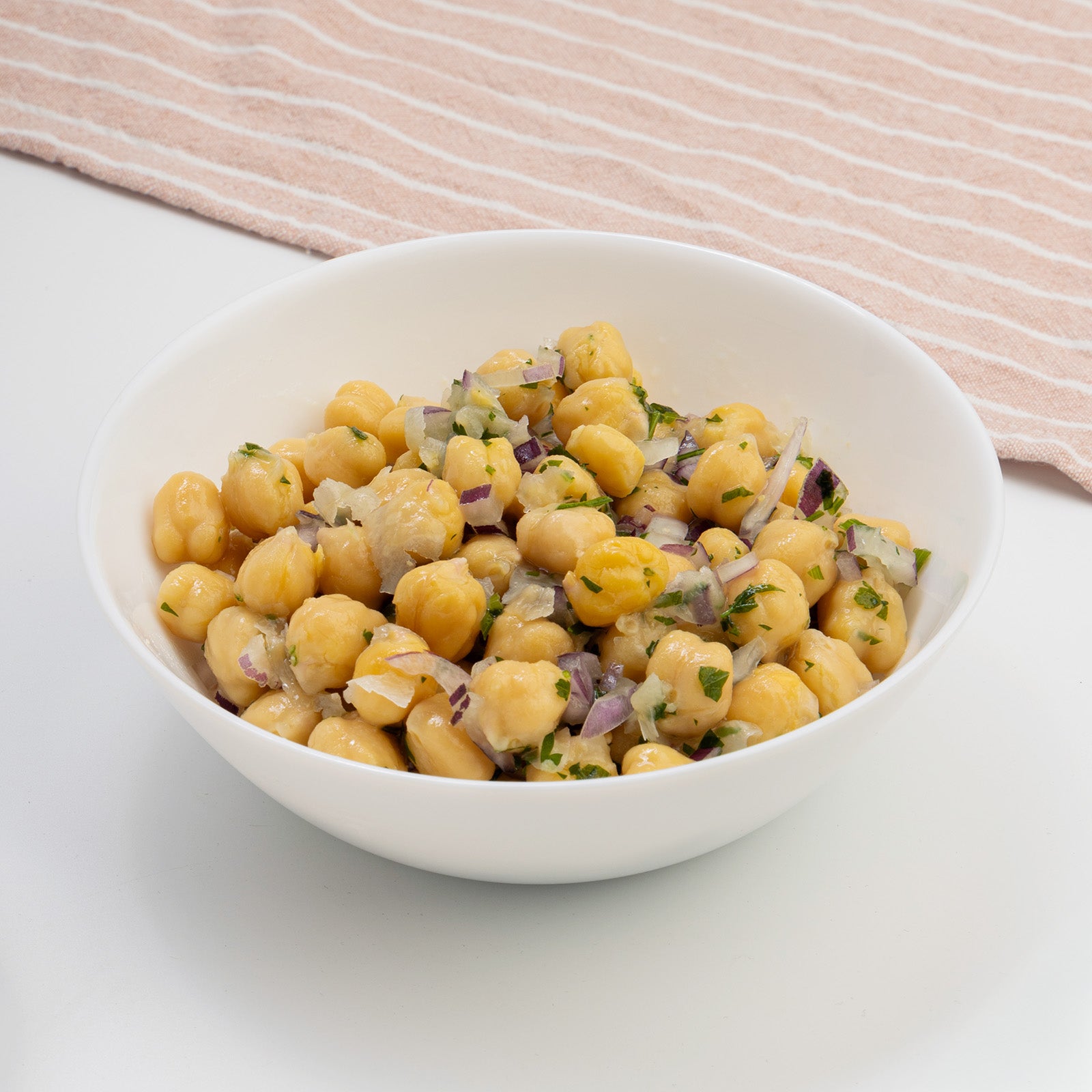 Zina's Fine Foods Italian Chickpea Salad in a white bowl with red onion and fresh parsley
