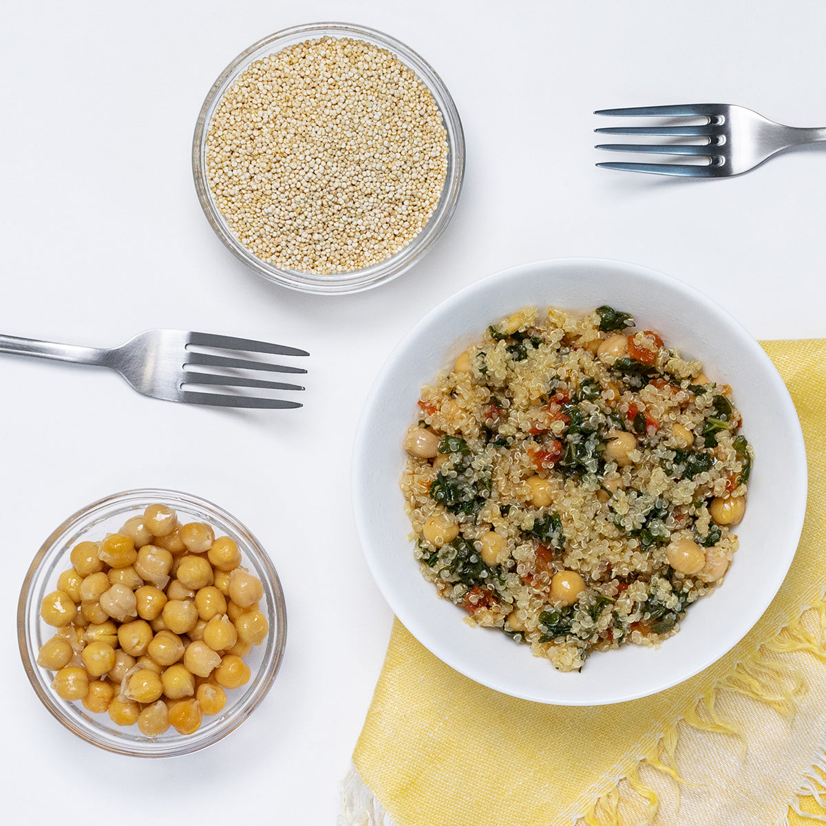 Zina's Fine Foods Kale and Quinoa Bistro Salad styled with raw quinoa and chickpeas in side bowls