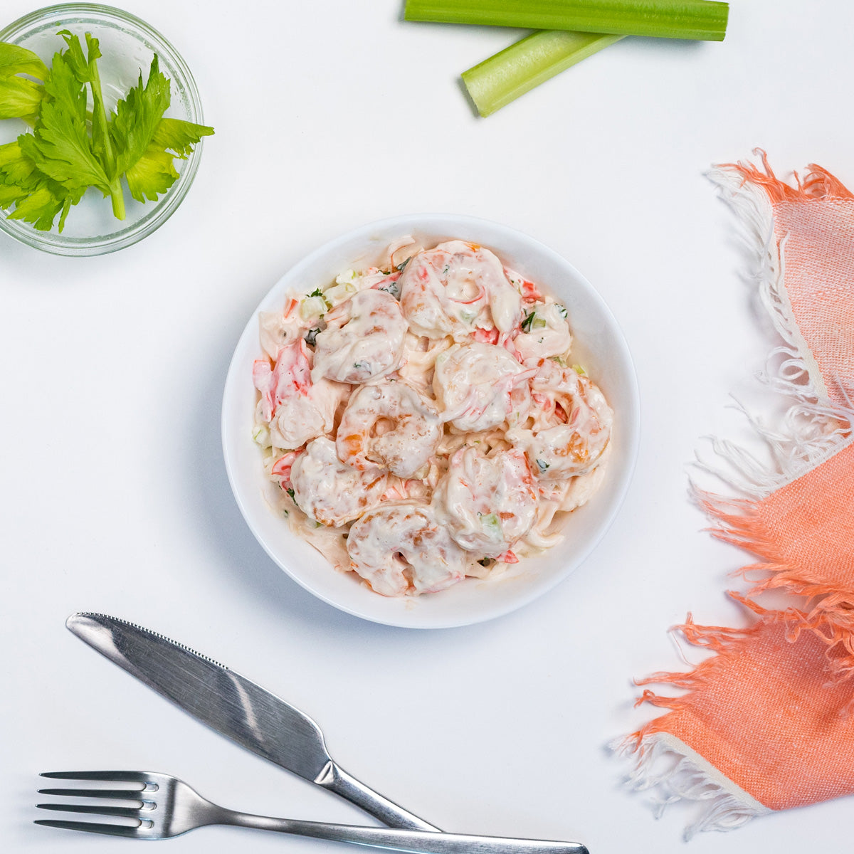 Shrimp Salad with whole shrimp in creamy dressing and peppers in a white bowl by Zina's Fine Foods