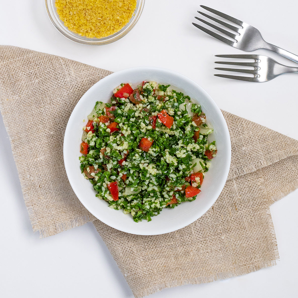 Tabbouleh Salad with bulgur, parsley and diced tomato in a white bowl by Zina's Fine Foods