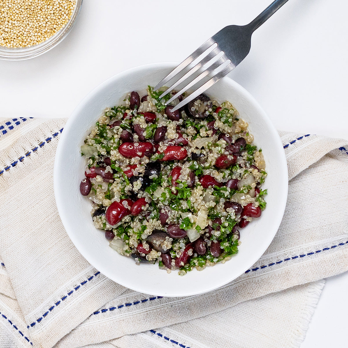 Vegan Quinoa Salad with quinoa, kidney beans and fresh parsley in a white bowl by Zina's Fine Foods