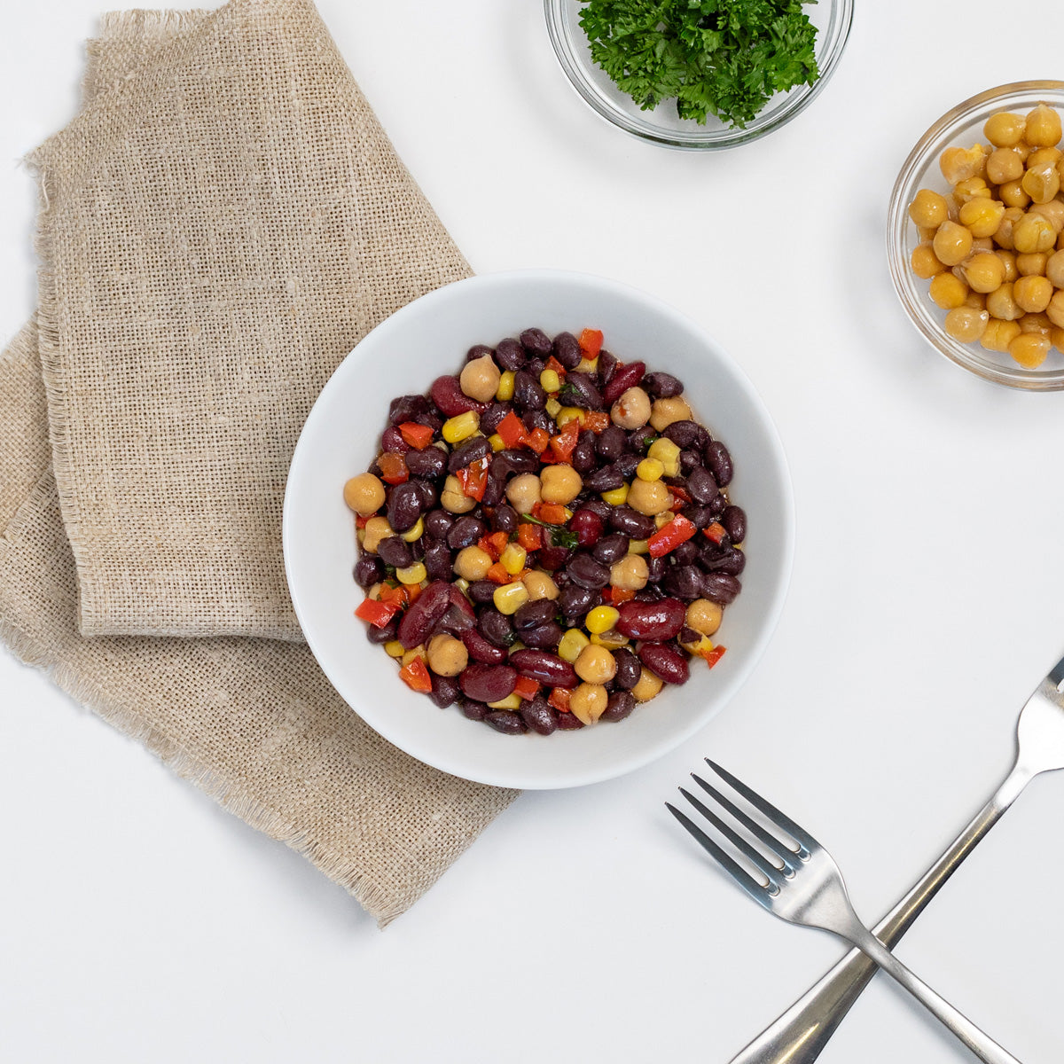 Black Bean Salad with kidney beans, chickpeas, corn and red pepper in a white bowl by Zina's Fine Foods